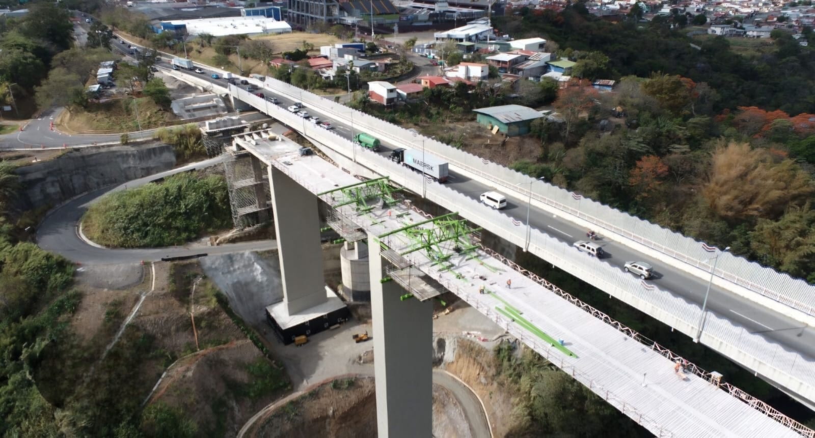 Vista aérea de dos puentes; en el puente superior se observan barandas altas a ambos lados de la vía.